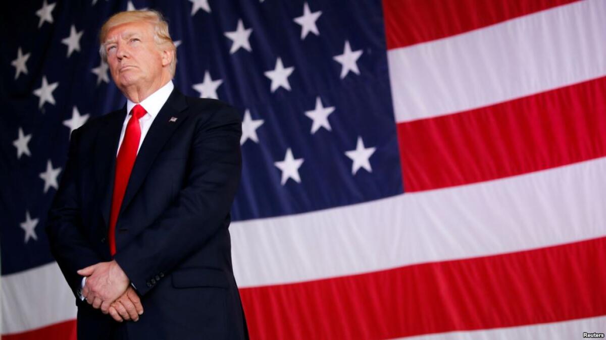 Il progetto di Trump per cambiare l'economia americana - Foto del Presidente USA, Donald John Trump, con la Bandiera Americana. Source: VOA News