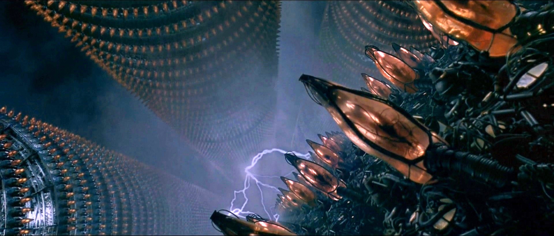 Scena del film The Matrix, dove Neo si sveglia dal "coma" e scopre la realtà. Miliardi di corpi imprigionati in incubatrici, dormendo e offrendo la loro energia alle macchine.