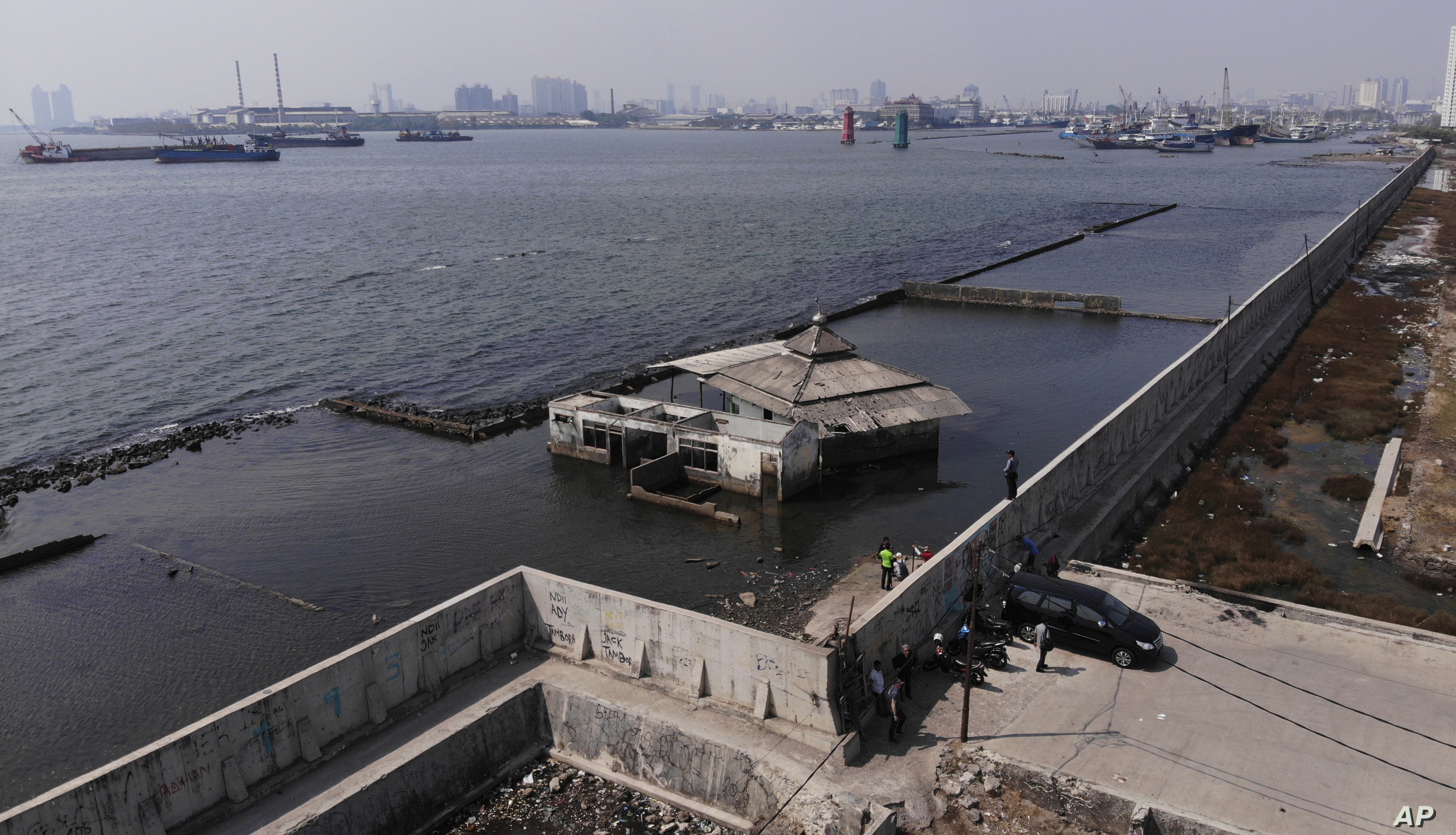 Il muro costruito a protezione delle aree a confine con l'oceano. Alcune case al di la del muro sono ormai sommerse. PH: www.voanews.com