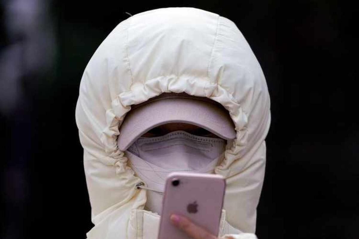 Coronavirus: Amuchina e mascherine a prezzi stellari - A woman wearing a mask checks her mobile phone in Shanghai, China January 29, 2020. REUTERS/Aly Song     TPX IMAGES OF THE DAY - RC2NPE9UQP81