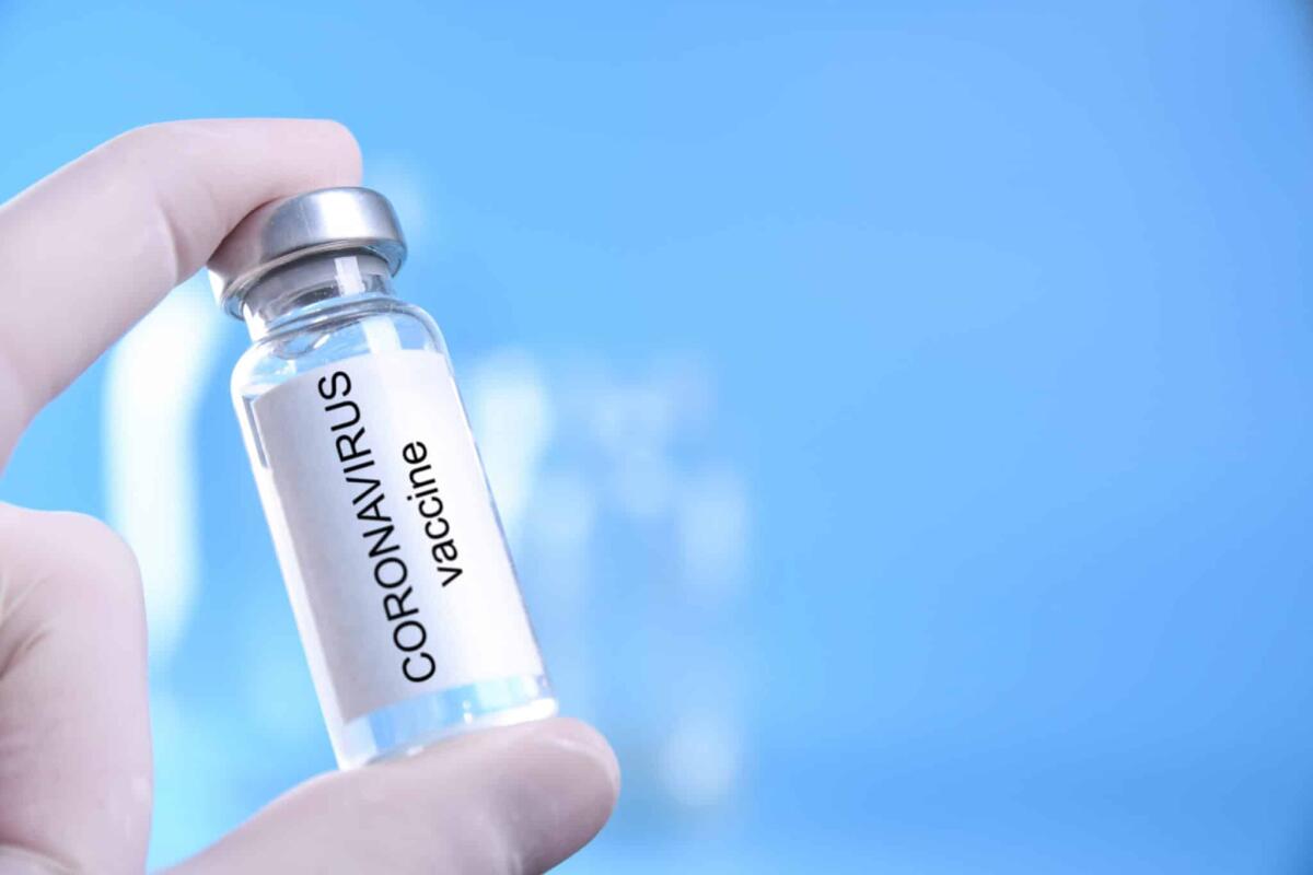 Coronavirus, sperimentazione umana per il vaccino americano - Doctor or nurse hand with nitrile glove holding coronavirus vaccine shot for baby vaccination, medicine and drug concept.