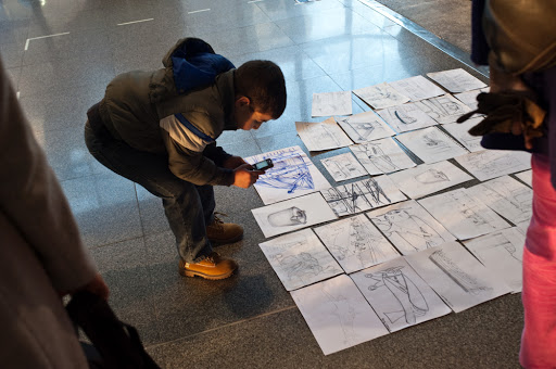 Un bambino fotografa i disegni di uno Sketchmob, da UrbanTV