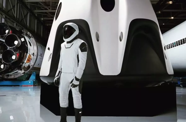 La nuova tuta davanti alla capsula Dragon2 e ad un razzo Falcon9