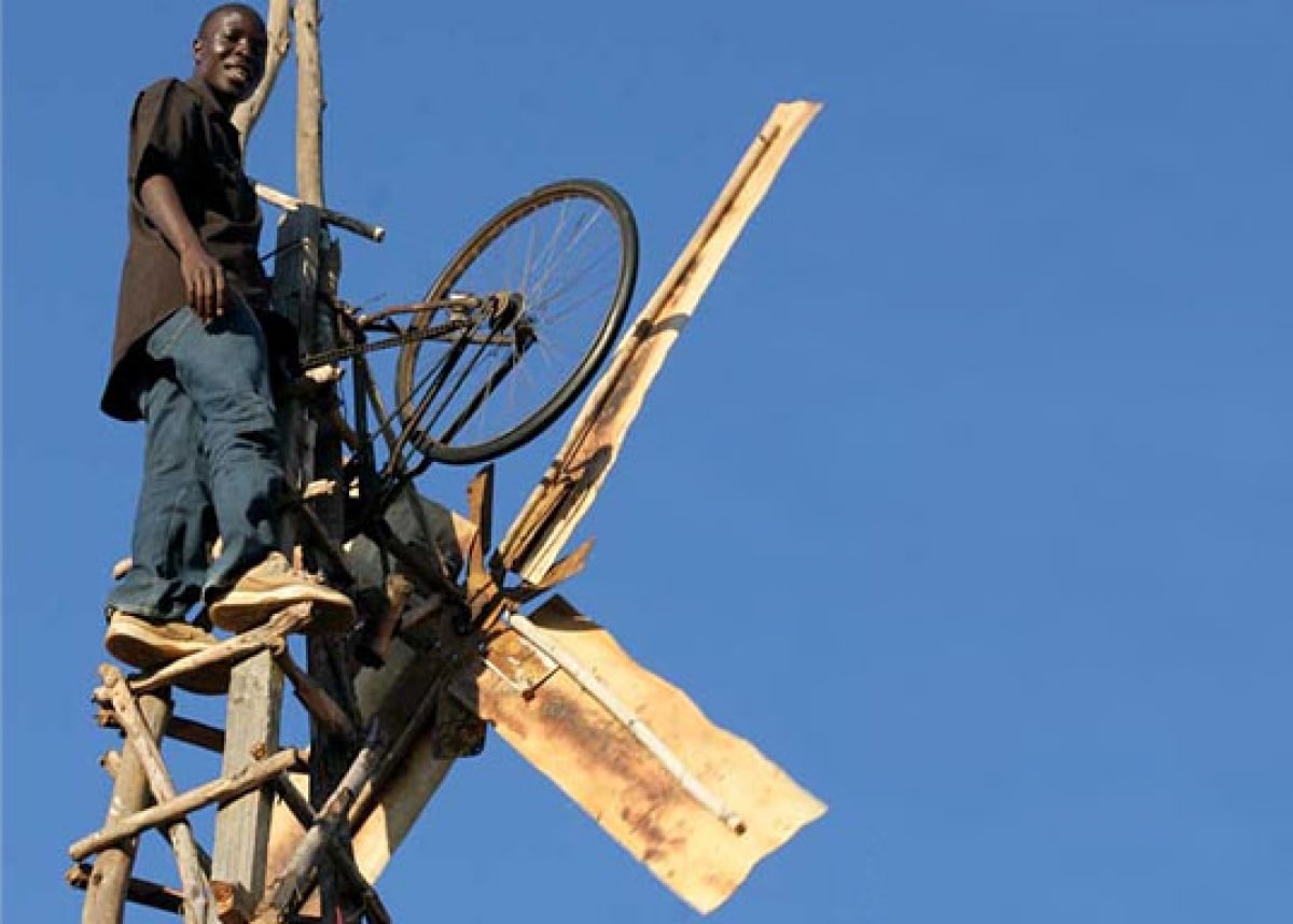 Immagine vera di William Kamkwamba sulla torre del mulino a vento da lui stesso progettato