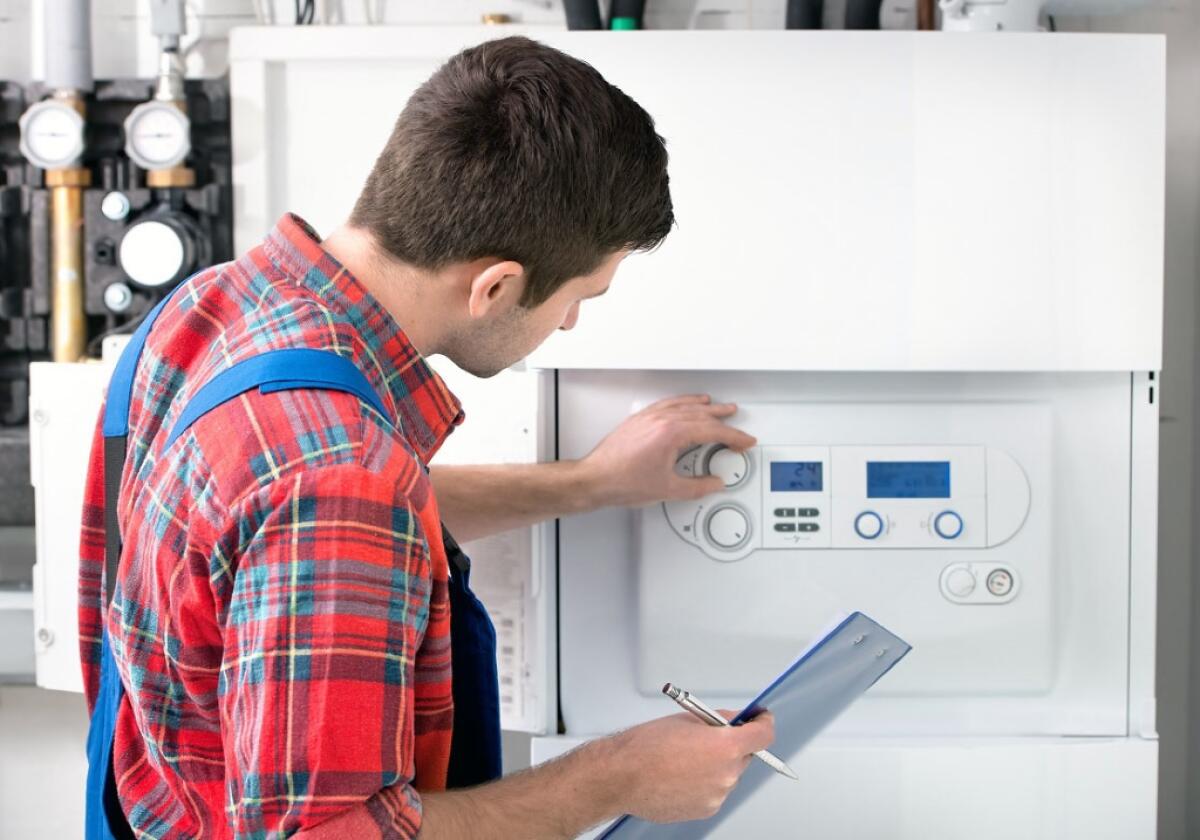Sostituzione della caldaia: tutto ciò che bisogna sapere - Technician servicing the gas boiler for hot water and heating
