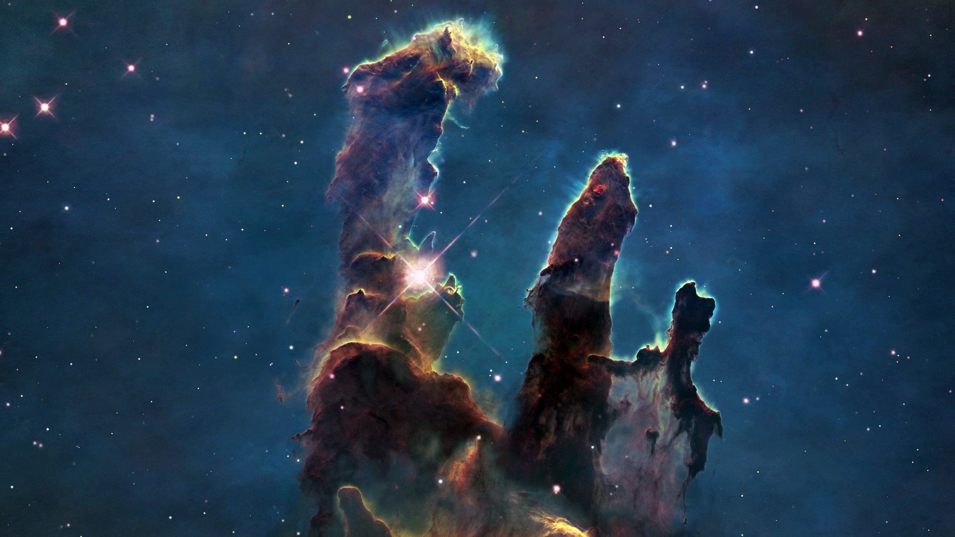 I Pilastri della Creazione ai raggi X di Chandra. Il colore della luce rivela l’intensità spettrale della radiazione X. Credits: X-ray: NASA/CXC/U.Colorado/Linsky et al.; Optical: NASA/ESA/STScI/ASU/J.Hester & P.Scowen.