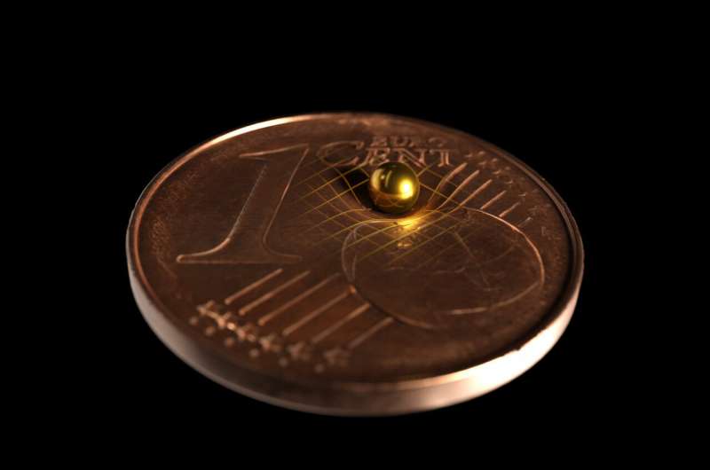Sfera di oro usata per l'esperimento gravitazionale, comparata a una moneta da 1 centesimo di Euro. Crediti: Tobias Westphal / Arkitek Scientific