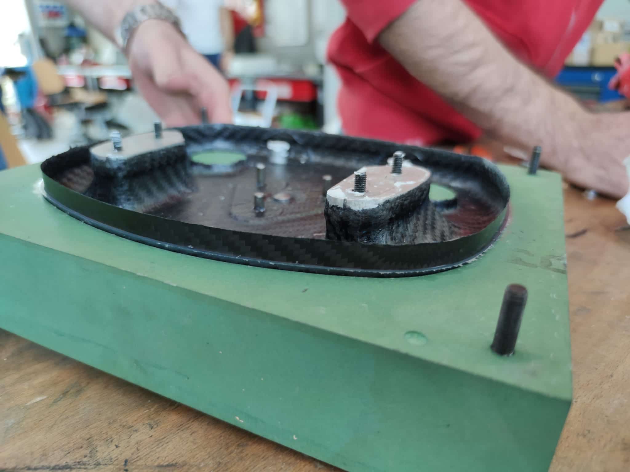 Uno dei due semigusci laminati in carbonio pronto per essere estratto dallo stampo dopo la "cottura".