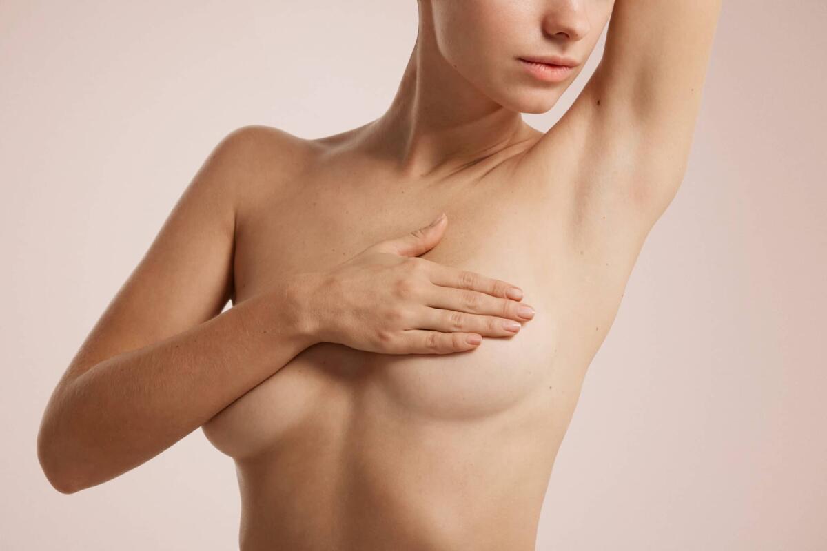 Cancro al seno, il deep learning può aiutare a prevenirne i rischi - Closeup cropped portrait young woman with breast pain touching chest colored isolated on background