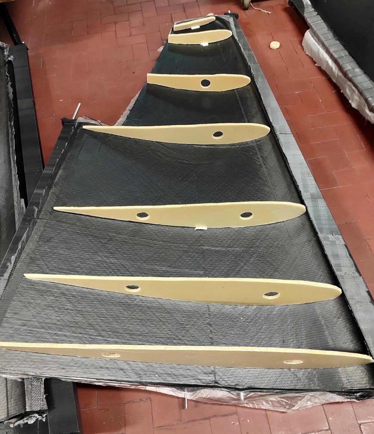 Esempio di parte della semiala (durante la costruzione dell'aeromodello SIAI Marchetti) con laminato in fibra di carbonio per la realizzazione dello skin. Crediti: Team 55.