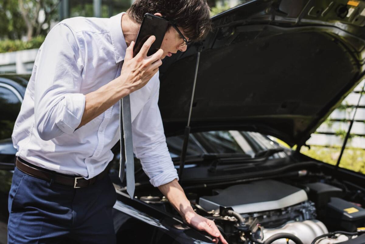 Assicurazione auto con satellitare: pro e contro - Man calling for help to fix his car