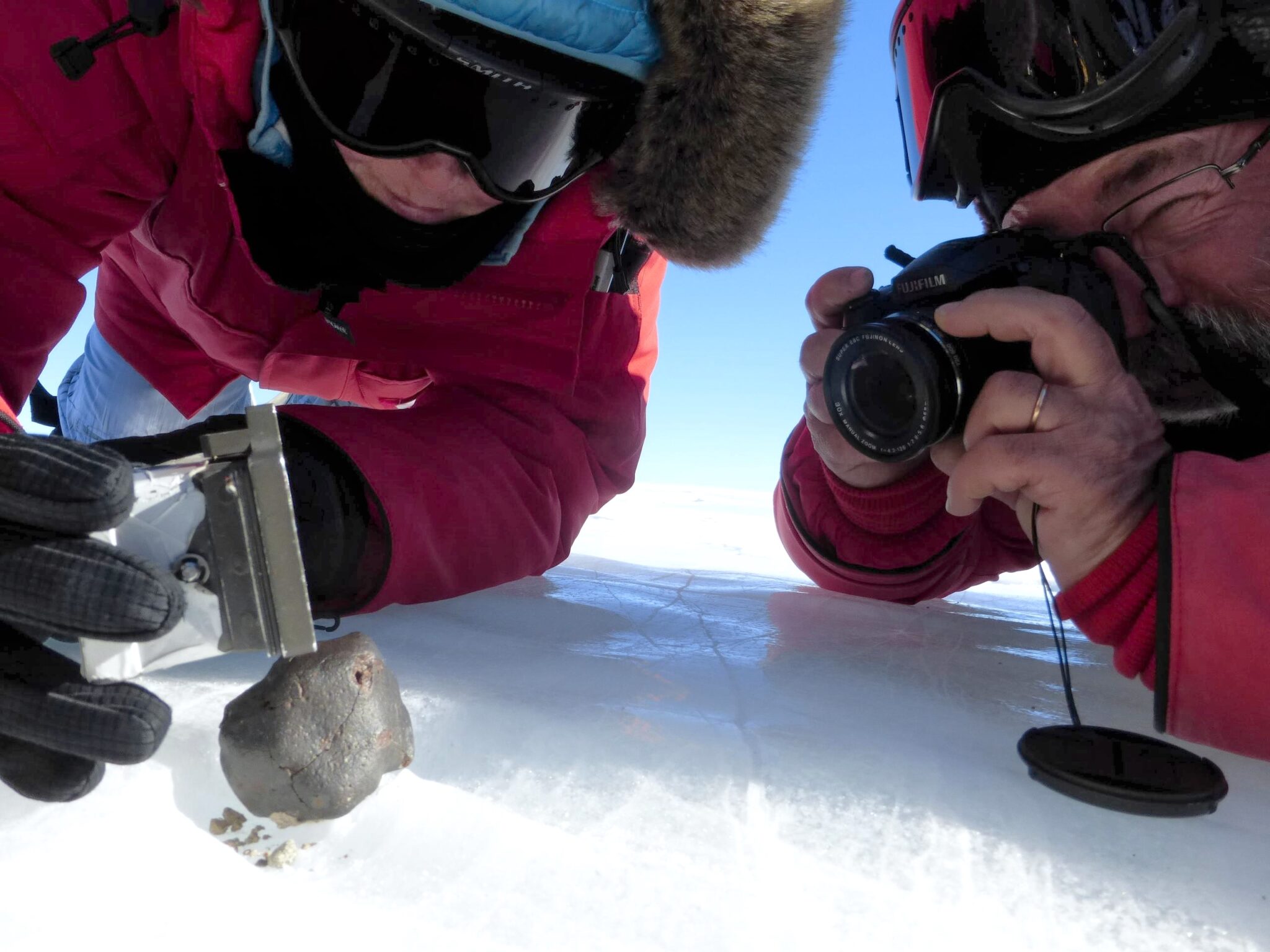 Scienziati che esaminano il meteorite su un terreno innevato, nel Miller Range in Antartide.
