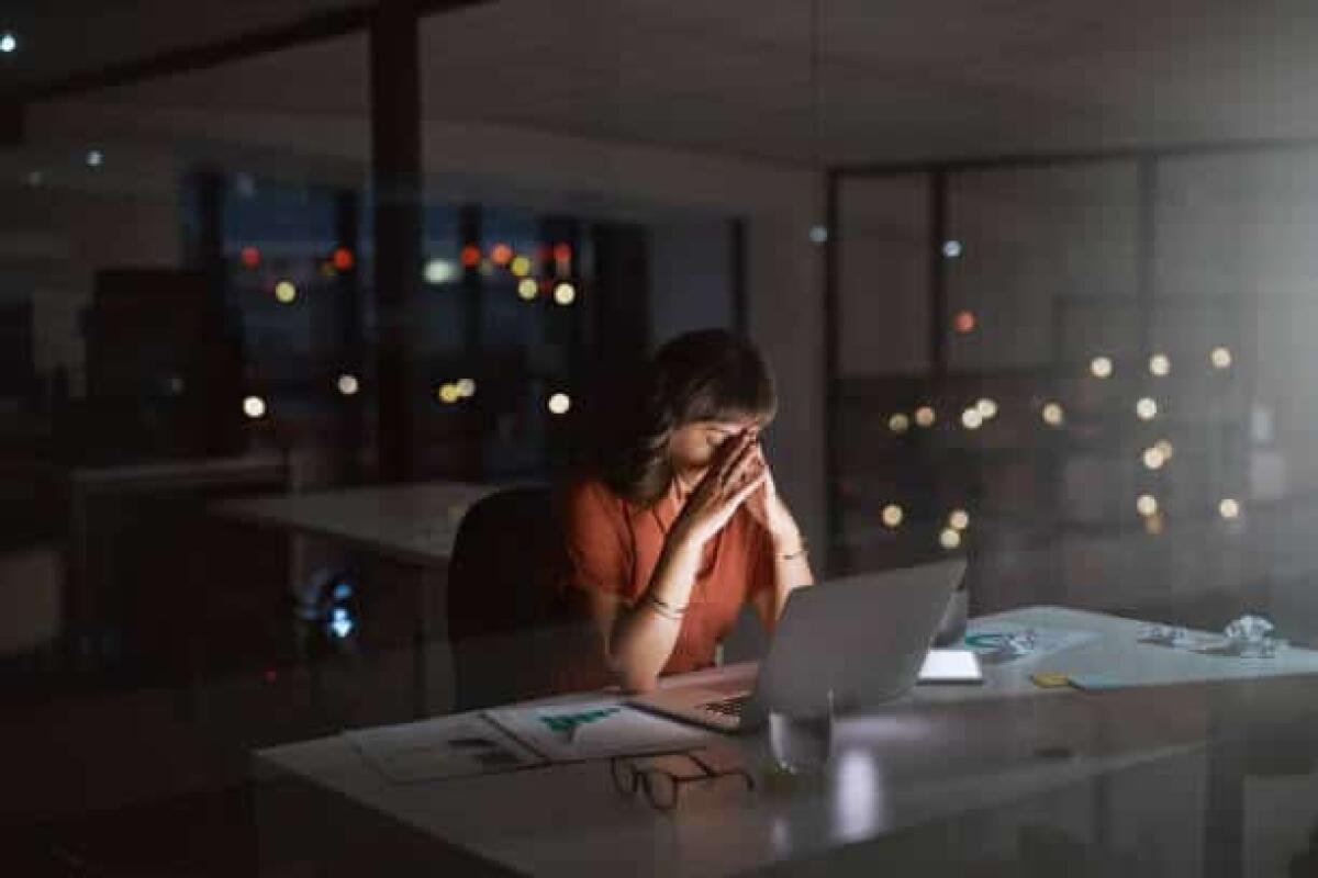 Personalità e skill mismatch: uno studio tutto italiano - Shot of a young businesswoman looking stressed out while working on a laptop in an office at night