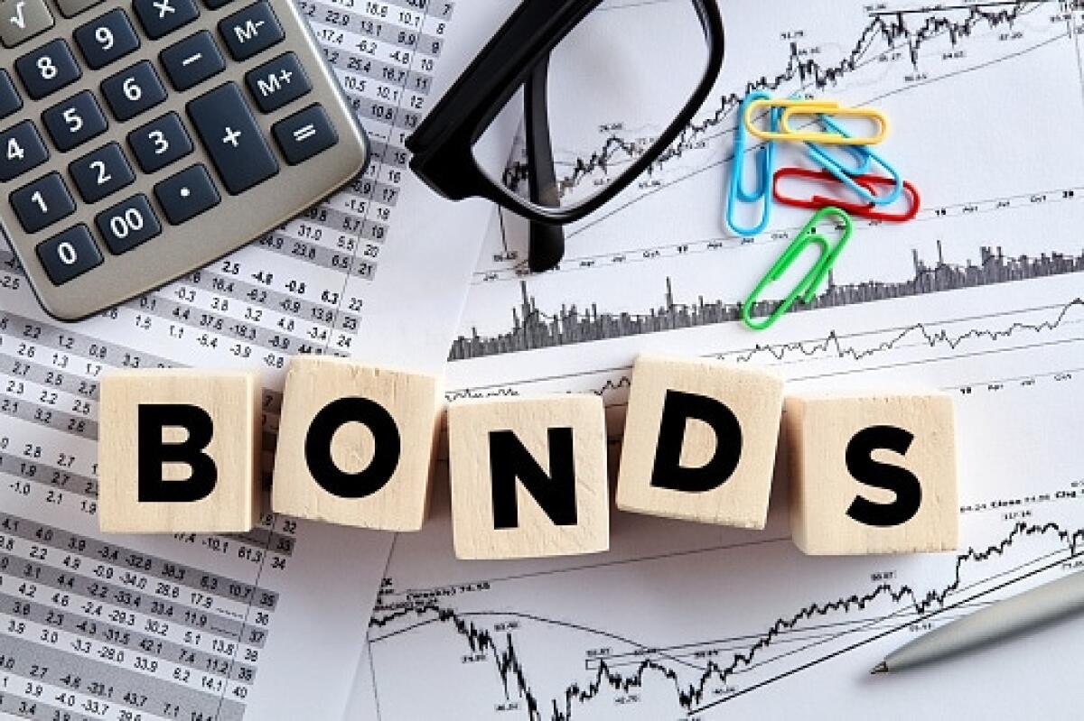 Cosa sono i Titoli di Stato? - The word bonds on wooden cubes with office desktop. Business finance stock exchange concept.