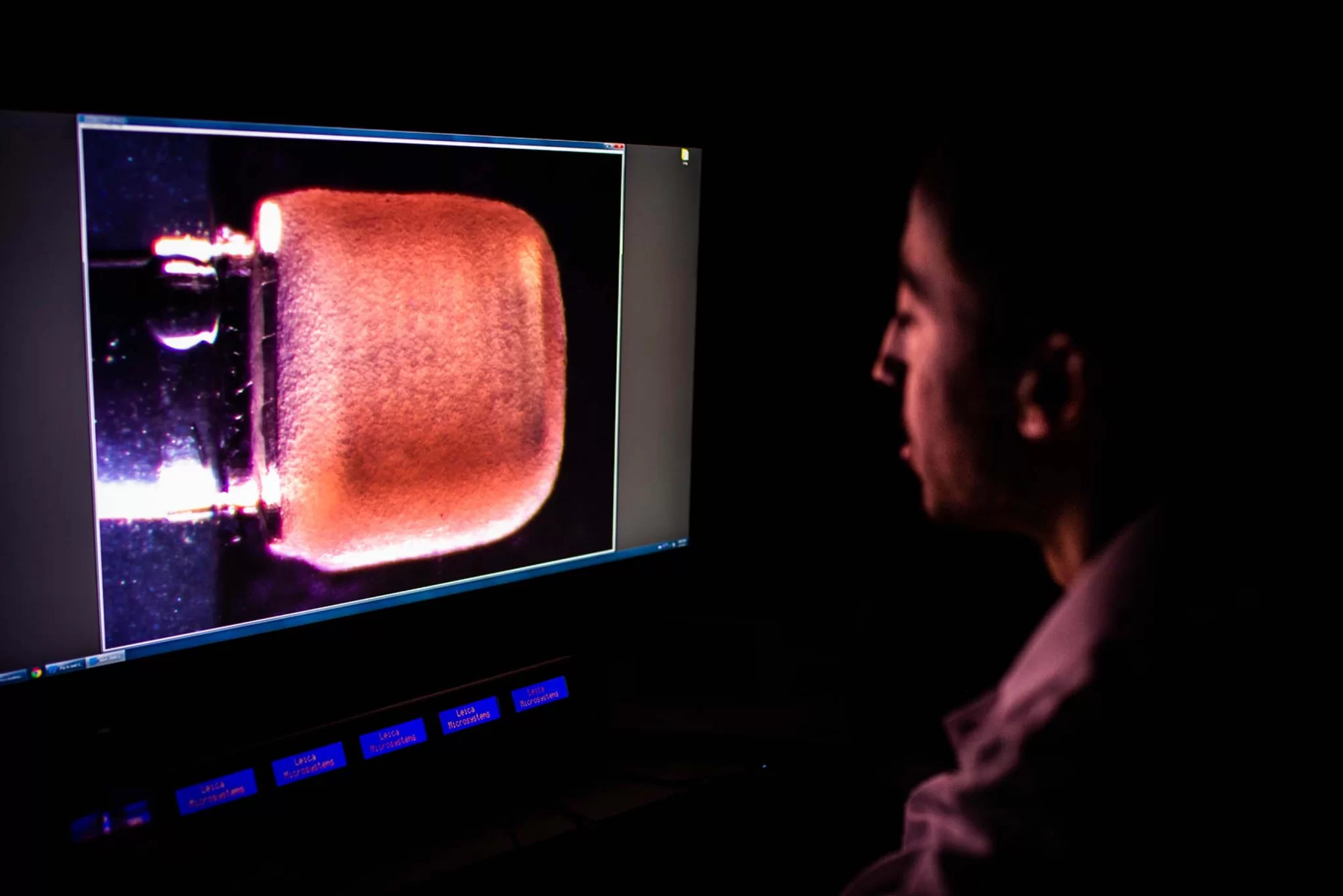 Christos Michas (scienziato responsabile dello studio) guarda la pompa in miniatura - Credits: Jackie Ricciardi per Boston University Photography.