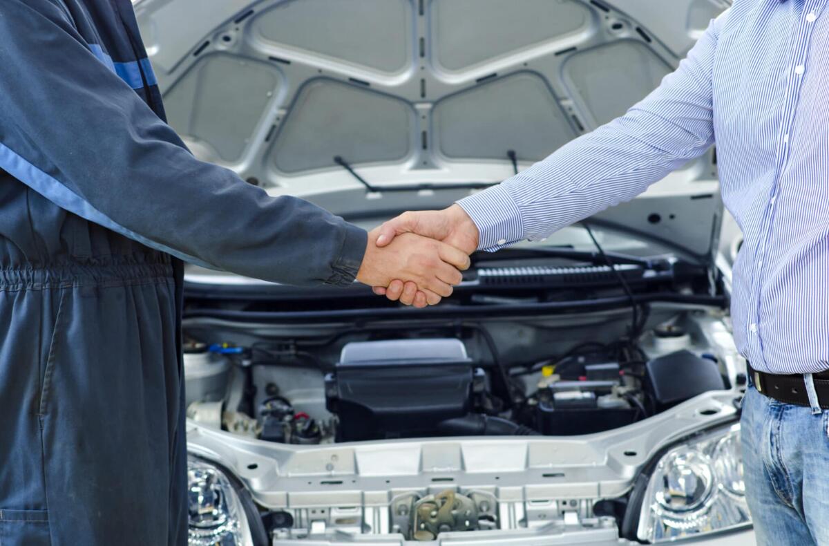 Come trovare il carrozziere giusto - Car mechanic and customer shaking hands.