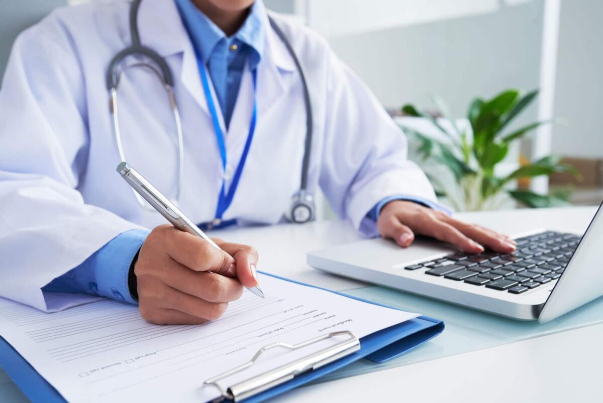 Tumori gastrointestinali: l'evoluzione della terapia CAR-T - Doctor checking information in computer program before filling medical card