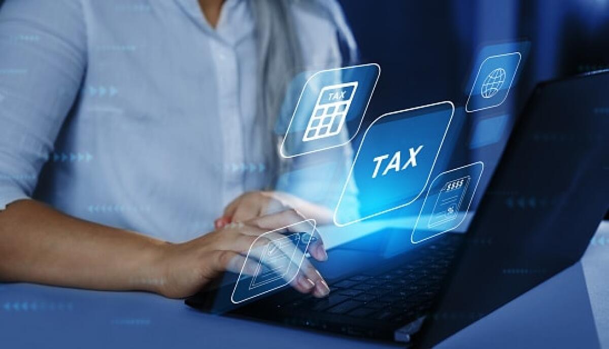 Partita IVA, per la fiscalità di liberi professionisti e imprese - Business Woman using a laptop with digital graphic screen to complete income tax form online. Financial research,government taxes and calculation tax return concept. Tax Time.