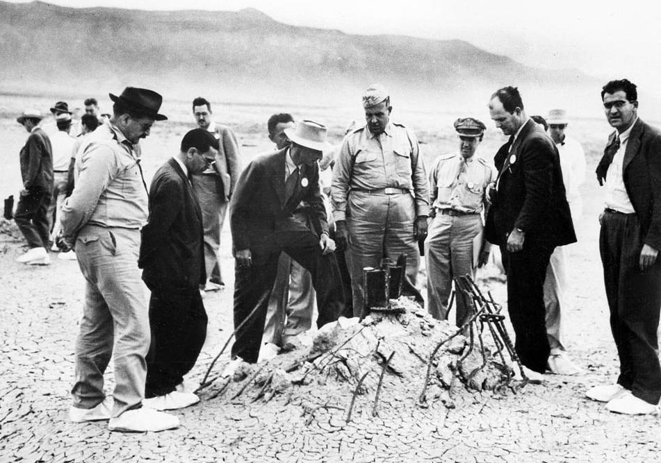 Robert Oppenheimer ed il Generale Groves sul sito del primo test atomico qualche settimana dopo l'esplosione (1943); si notano le scarpe coperte per evitare di contaminarle con le polveri radioattive del fallout nucleare. Credits: United Stated Department