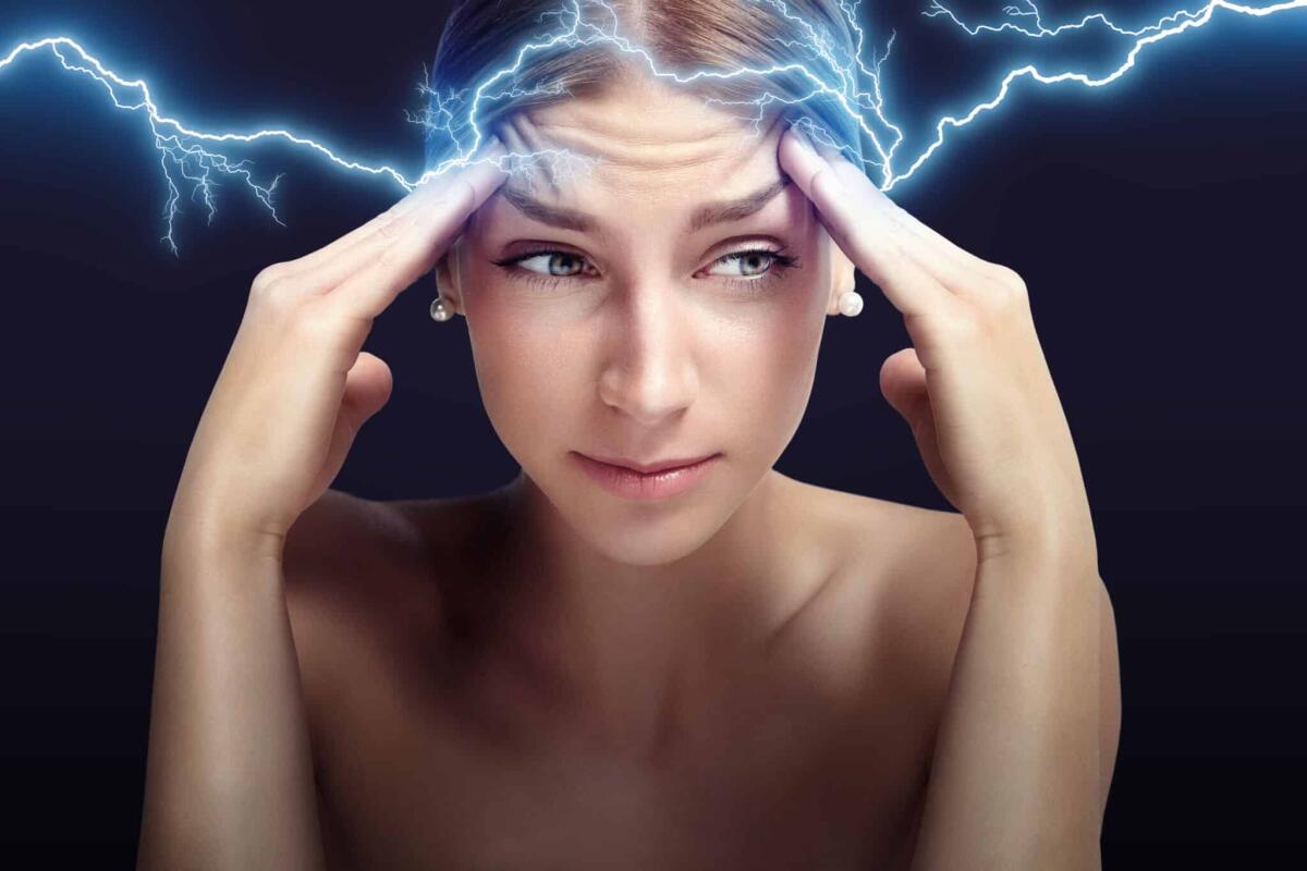 Emicrania: MRI rivela cambiamenti cerebrali in chi ne soffre - woman with headache on black background with thunder draw