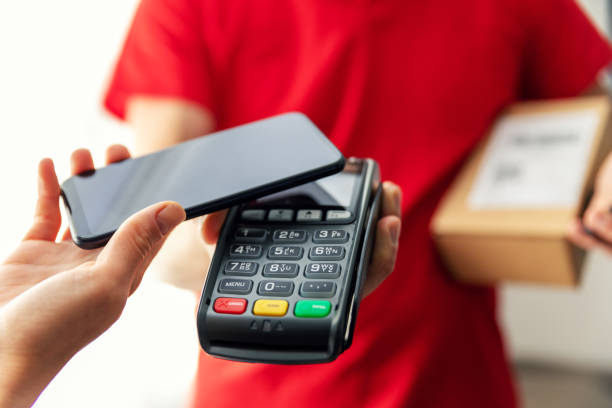 consegna pacchi in pagamento con pagamento nfc contactless con telefono - pos foto e immagini stock