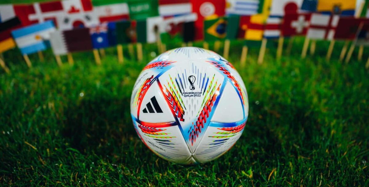 Al Rihla: ecco come funziona il pallone super hi-tech di Qatar 2022 - QATAR, DOHA,  2022: FIFA World Cup Qatar 2022  Official Adidas Ball on green grass and national flags of all 32 participants.