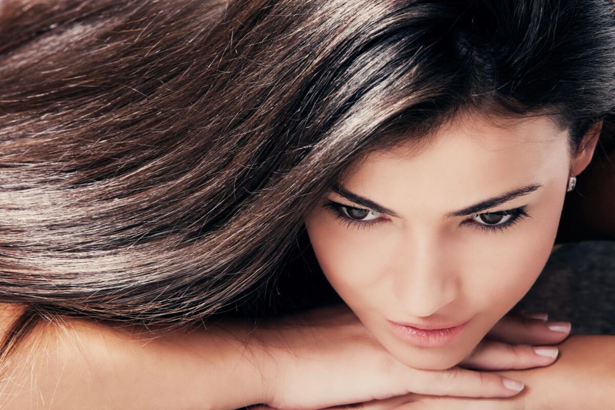 Biotina: quale ruolo svolge nella crescita dei capelli? - dark hair young beautiful woman portrait