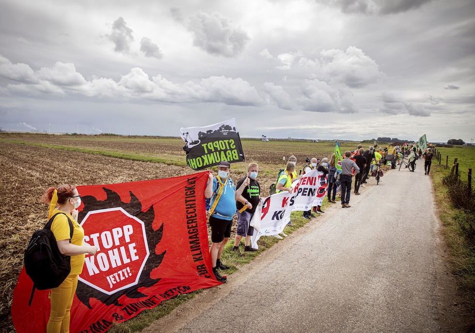 Environmental and climate activists as well as residents of neighbouring villages have form a human chain on the edge of the Garzweiler open-cast mine in Juechen, Germany, Saturday, Aug. 7, 2021. About 2,500 people have protested for a quick exit from coa
