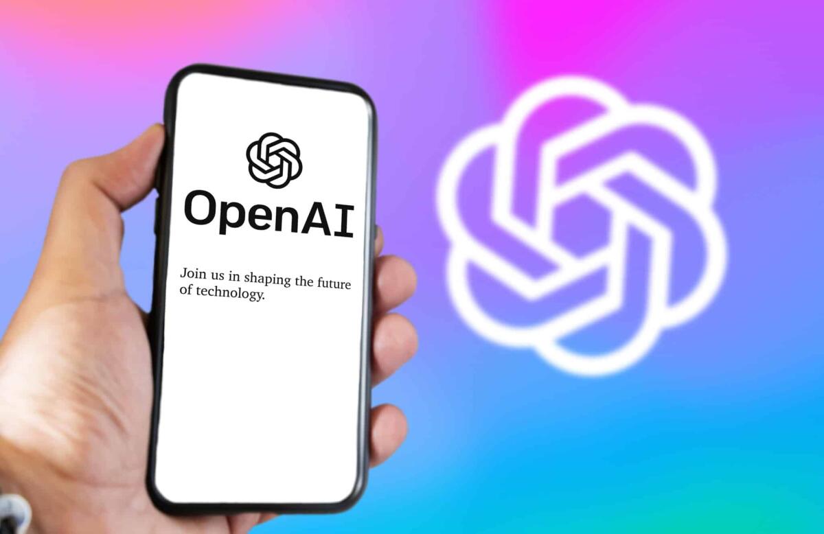 ChatGPT Plus: OpenAI introduce il nuovo servizio a pagamento - San Francisco US, Dec 2022: A hand holding a phone with the OpenAI website on the screen. Colorful background with blurred logo. OpenAI is a non-profit artificial intelligence research organization.