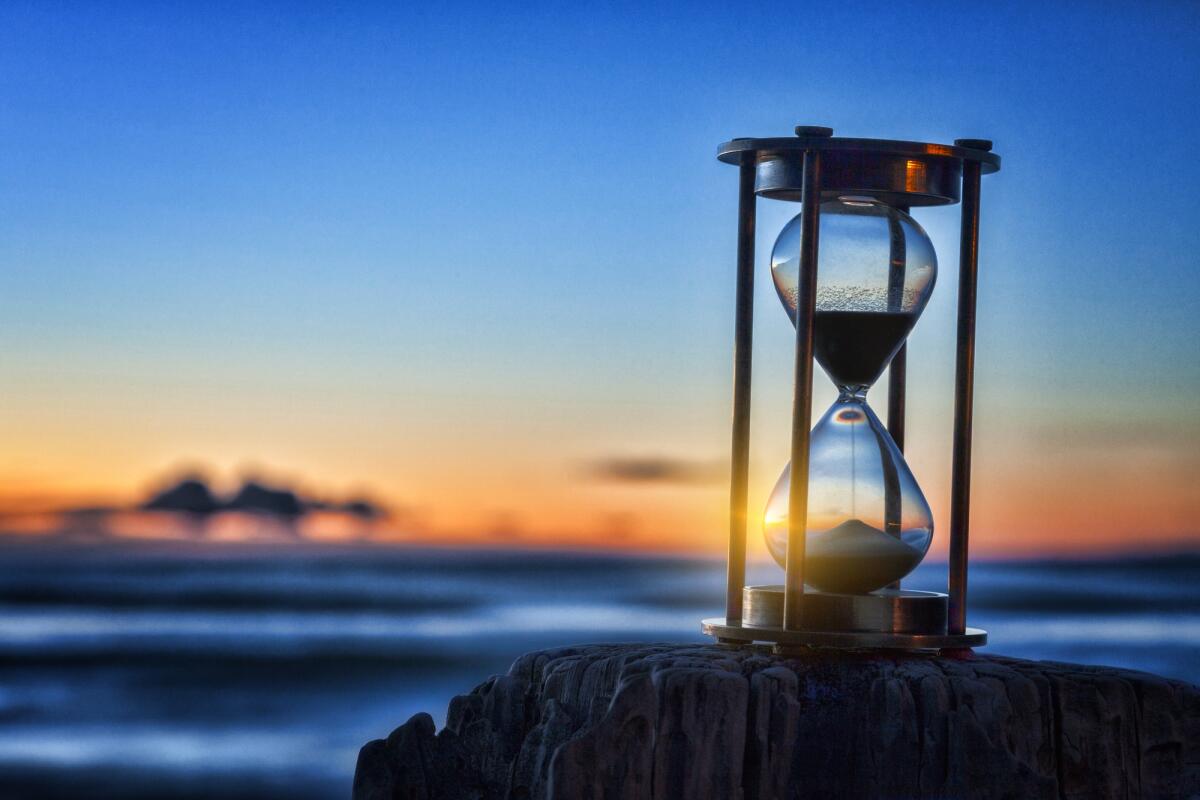 Percezione del tempo: potrebbe essere influenzata dal battito cardiaco - Hourglass or sand timer in front of a beatiful clear sunrise or sunset.
