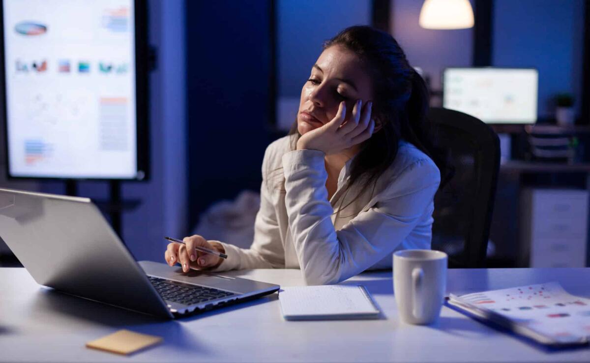 Stanchezza cronica da Long Covid: la scoperta italiana - Exhausted freelancer falling asleep in front of laptop checking financial reports in company office late at night. Manager using modern technology network wireless working on economic statistics