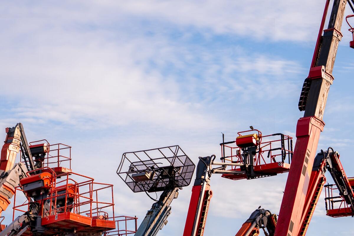 L'importanza della manutenzione delle piattaforme aeree per edilizia - Articulated boom lift. Aerial platform lift. Telescopic boom lift against blue sky. Mobile construction crane for rent and sale. Maintenance and repair hydraulic boom lift service. Crane dealership.