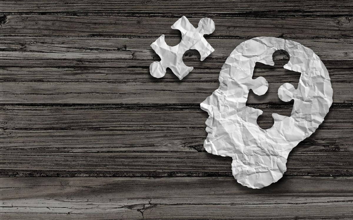 Salute mentale: perché è cosi importante? - Mental health symbol Puzzle and head brain concept as a human face profile made from crumpled white paper with a jigsaw piece cut out on a rustic old double page spread horizontal wood background.