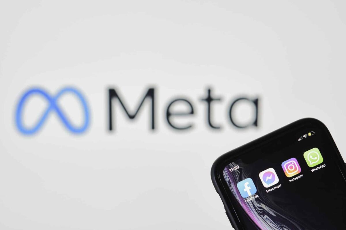 Meta: niente accordo con la Siae, stop alla musica - Tashkent, Uzbekistan - 29 October, 2021: Concept of Facebook changing name to Meta. Hand holds smartphone with Facebook logo over New META logo. Facebook rebrands to Meta and adopts infinity loop logo