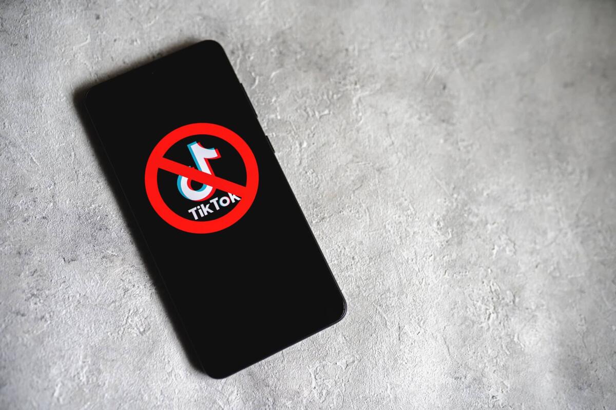 Blocco TikTok: Commissione Europea dice stop ai dipendenti - TikTok app logo crossed out with red Ban sign displayed on phone screen. Tik Tok banned in the US concept. Concrete background with copy space. Swansea, UK - February 15, 2023.