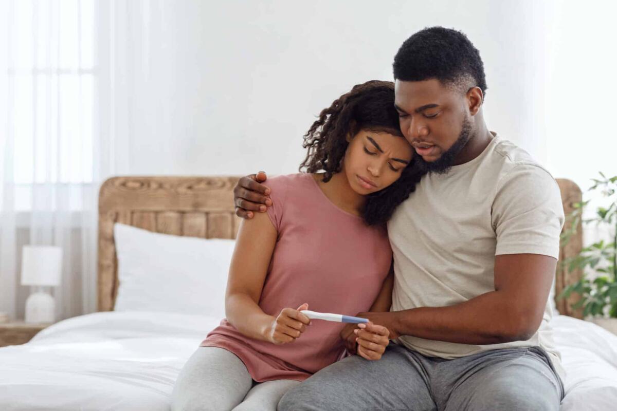 Infertilità: secondo l'OMS una persona su 6 è infertile - Upset african-american man and woman looking at negative pregnancy test, empty space