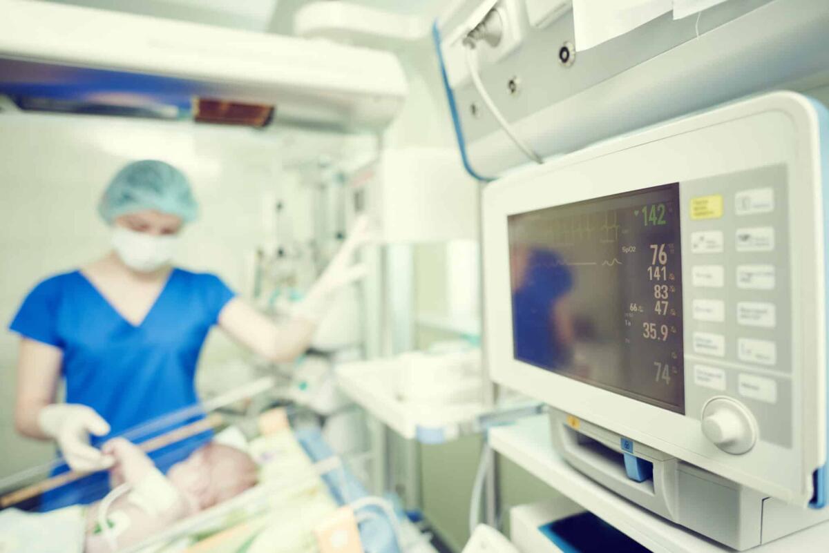Crisi convulsive neonatali: modello AI aiuta nella previsione - Surgery and intensive care unit. Female doctor or nurse in surgical child neonatal hospital with artifical lung ventilation device
