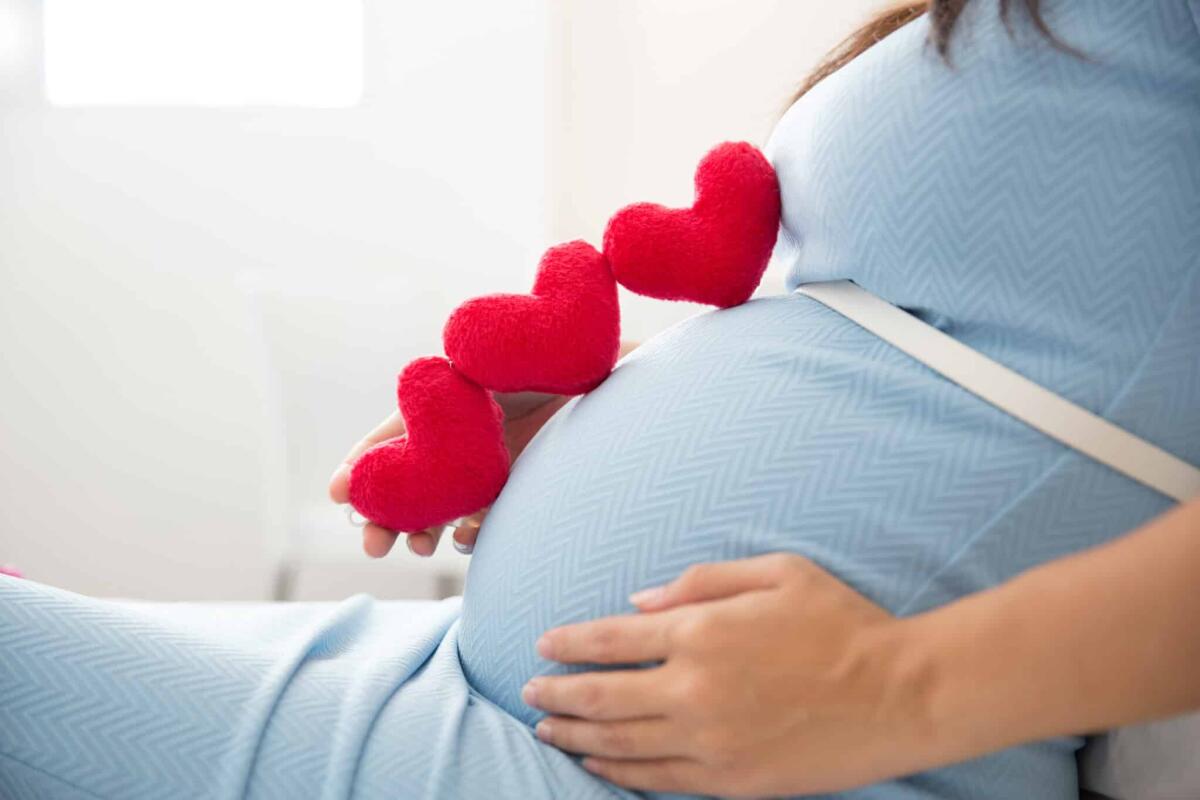 Parto prematuro: risultato di un conflitto tra i geni della madre e del nascituro? - A portrait of an Asian young pregnant woman put heart shape accessories in her tummy