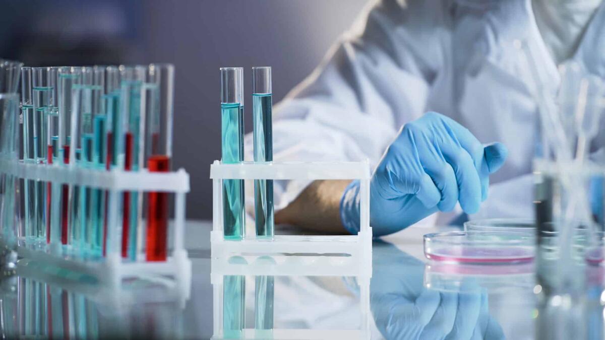 Citometria a flusso: caratteristiche e prospettive future - Medical scientist conducting test, observing reactions in glass flasks, research