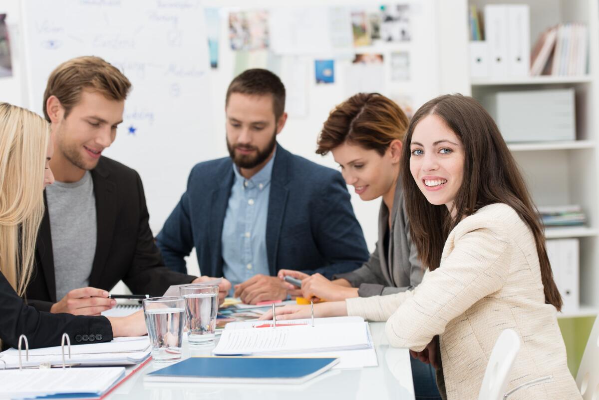 Governo Meloni e la legge sull’equo compenso dei professionisti - Group of dedicated young business professionals seated around a table in the office together having a meeting and sharing ideas
