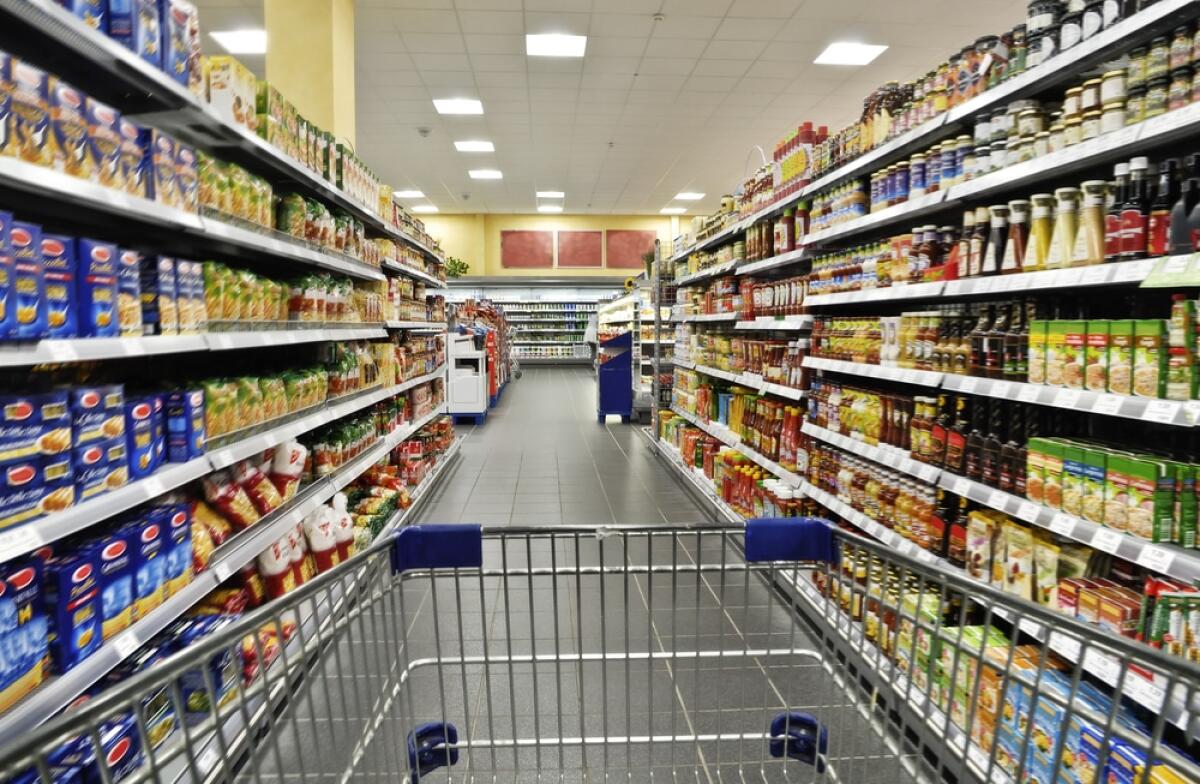 Carta risparmio spesa 2023: cos'è e come richiederla - An empty cart between shelves in the supermarket.