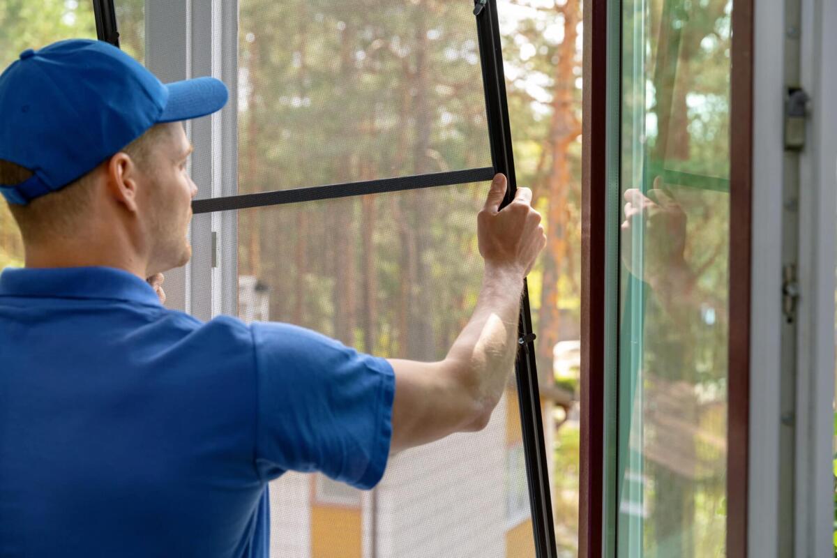 Bonus zanzariere: requisiti, come ottenerlo e documentazione - worker installing mosquito net wire mesh in plastic window frame