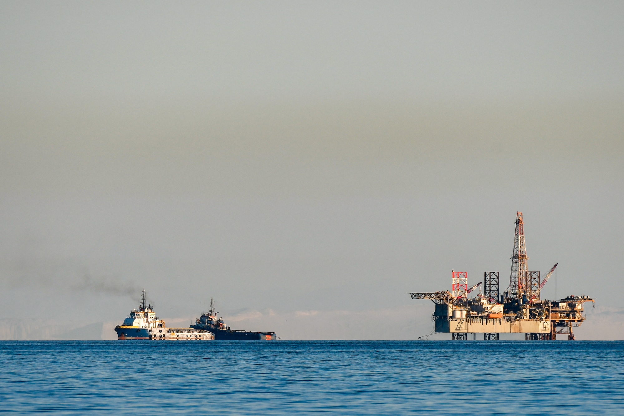 An oil drilling platform and cargo boats seen from the Egyptian mainland in the Gulf of Suez Red Sea