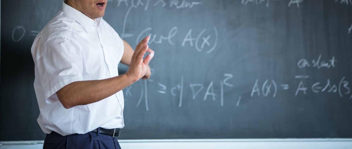 Come nacque il teorema della base di Hilbert - Senior male teacher teaching mathematics, writing on the blackboard