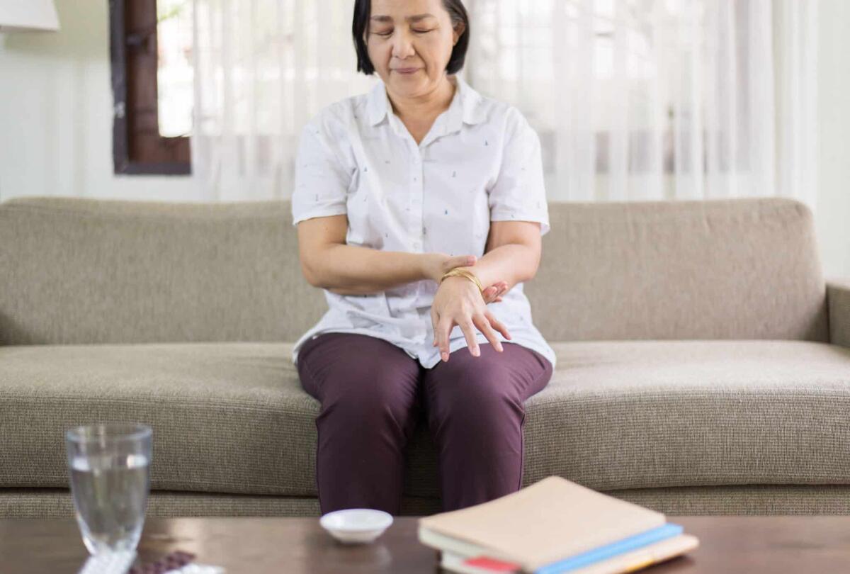 Cos'è la sindrome di Guillain-Barré? - Senior asian woman suffering with parkinson's disease symptoms on hands