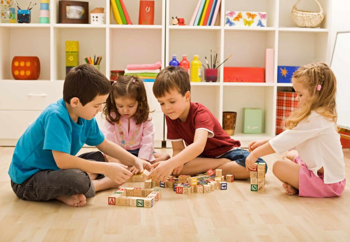 Nei bambini si è sviluppato un ritardo di quattro mesi a causa della pandemia - Children playing with blocks on the floor - focus on the boy's face