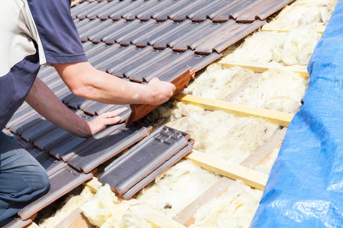 Rifacimento del tetto: cosa incide sul preventivo finale - a roofer laying tile on the roof