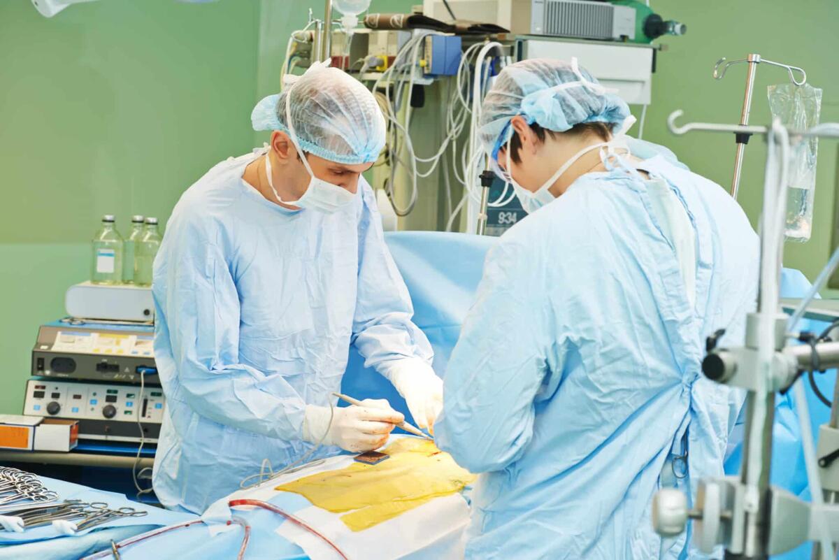 Cuore trasportato in un'ora da Trento a Bologna salva la vita di un uomo - Team of surgeon in uniform perform heart transplantation operation on a patient at cardiac surgery clinic