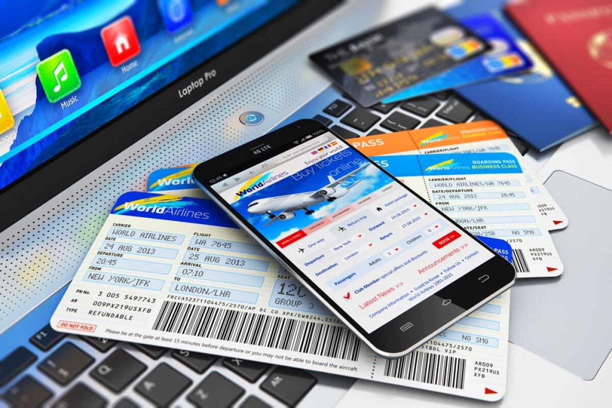 Compagnie aree dell'Ue contro il decreto sul caro-voli - Creative abstract business air travel, mobility and communication concept: modern touchscreen smartphone or mobile phone with airline internet web site offering booking or buying airliner tickets online, credit cards and passports on laptop or notebo
