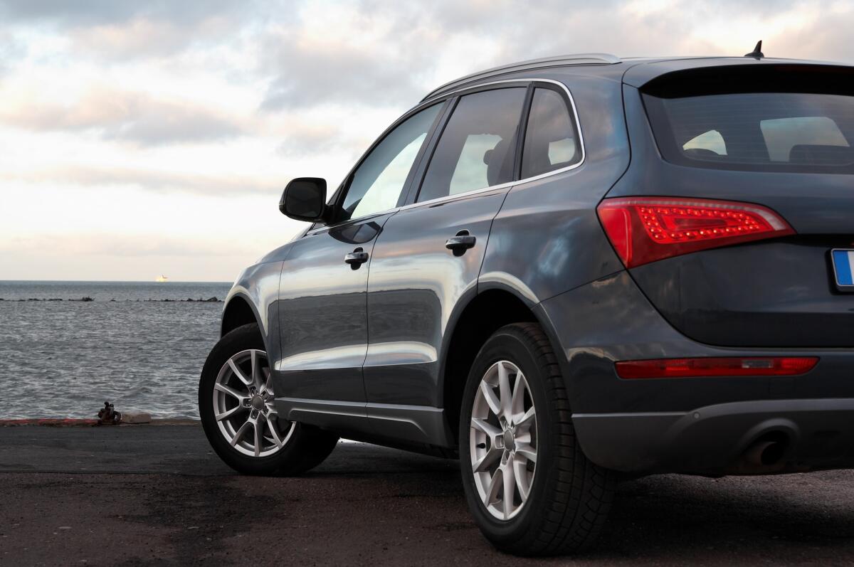 Gli italiani si sono innamorati dei crossover: quali sono i motivi? - Rear view of a luxury SUV parked near the sea